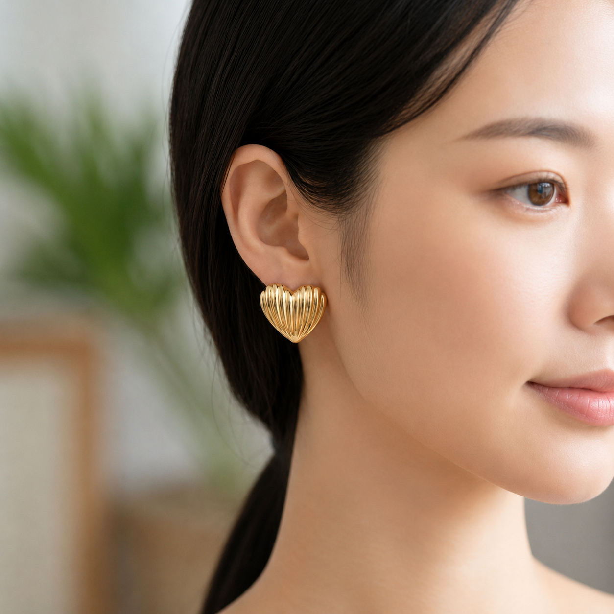 Flaire Studio ribbed gold heart stud earrings worn on model